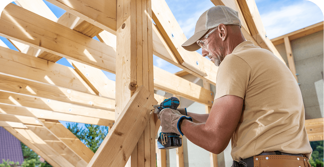 Man using drill on wooden beams